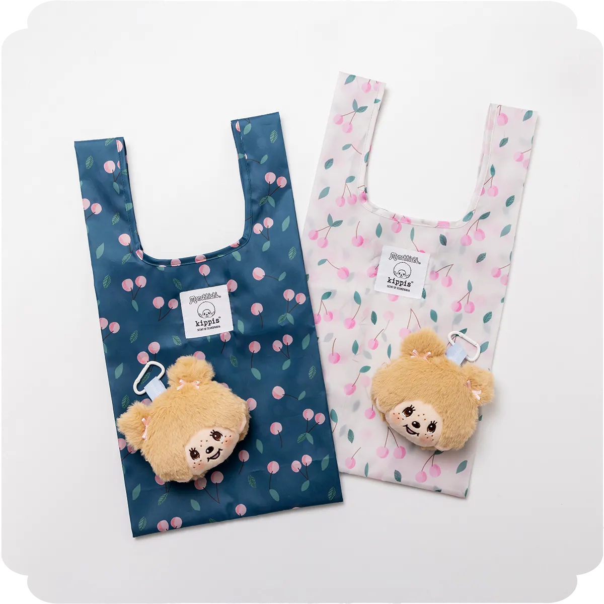 【商品写真】全体にKirsikka柄があしらわれているエコバッグ。ネイビーとオフホワイトの2種類。ファーで仕立てられたツインテールのモンチッチの顔のぬいぐるみチャーム付き