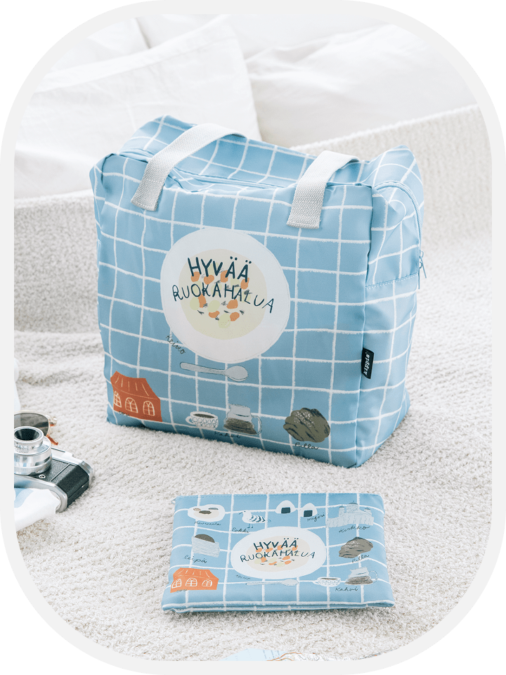 【商品写真】格子柄の上に「Hyvää ruokahalua」のイラストがデザインされている水色のボストンバッグ。中央には白い丸皿に盛られたサーモンスープ、周りには穀物パンやコーヒー、シナモンロール、おにぎりなどが描かれています。