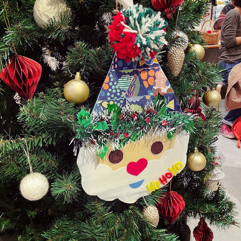 【写真】ワークショップで制作したサンタクロースの顔がツリーに飾られています